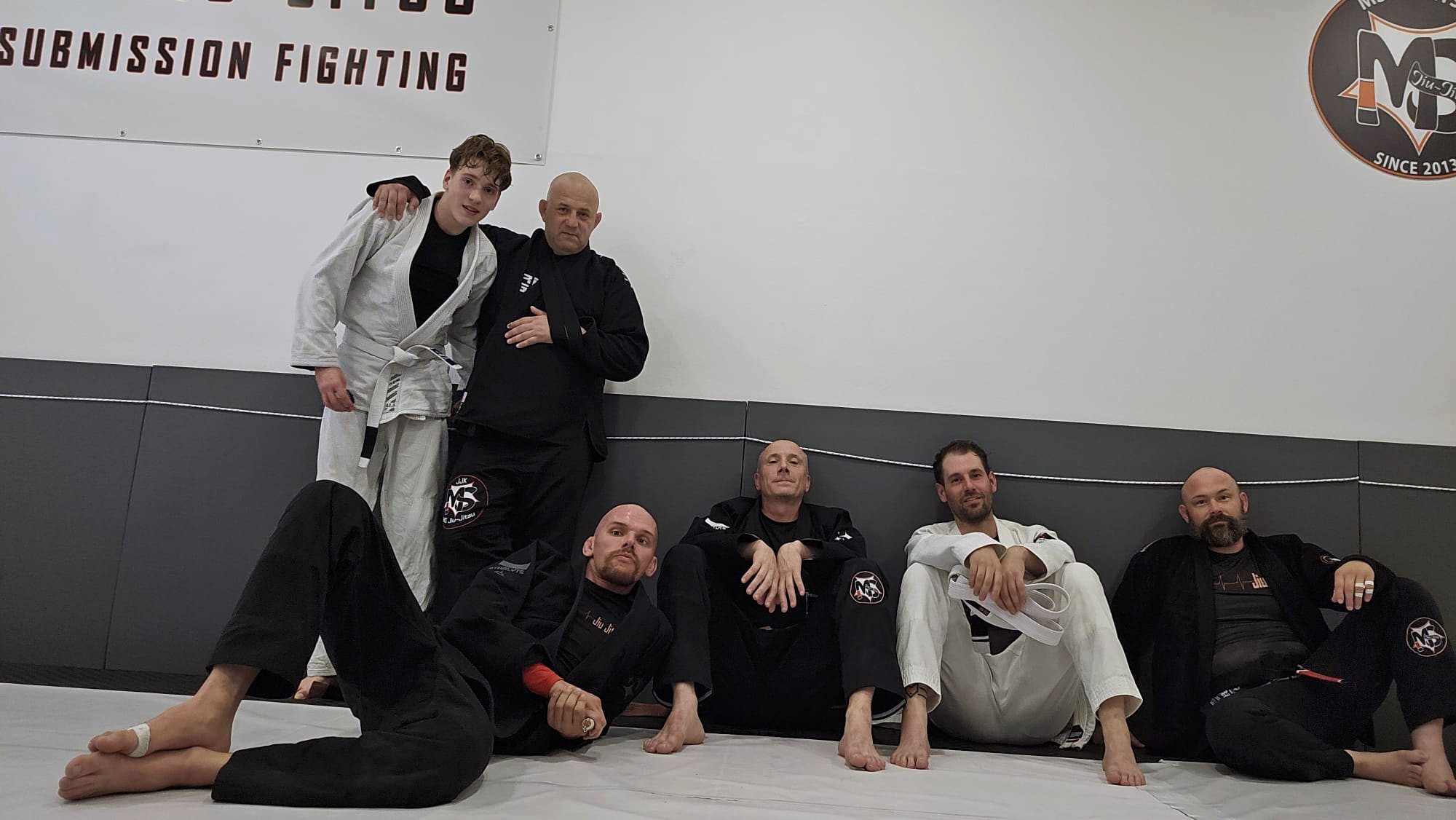 Gruppe nach dem Training an der Mattenwand in der Halle